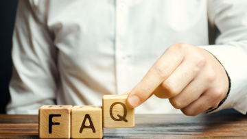 person placing wooden blocks with the word FAQ