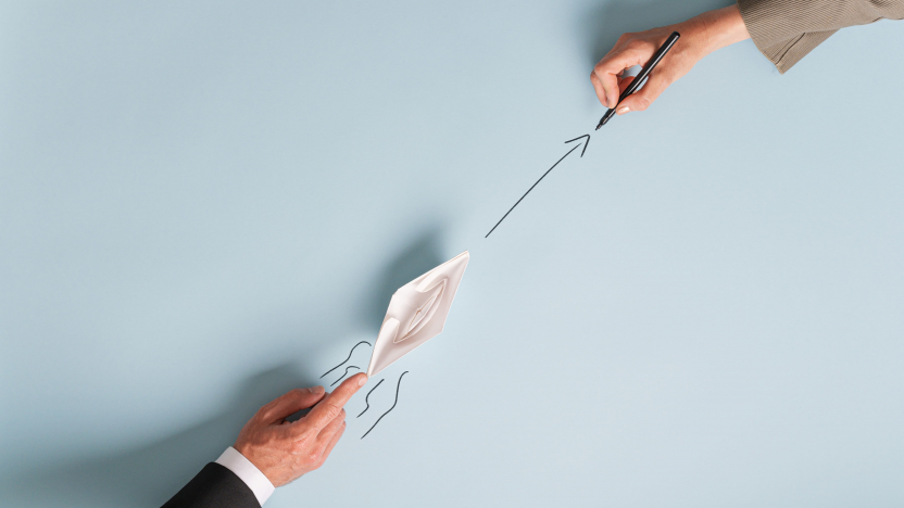 Vue d'en haut du travail d'équipe d'entreprise et du partenariat - main d'un homme d'affaires poussant le bateau à papier en origami dans une direction 