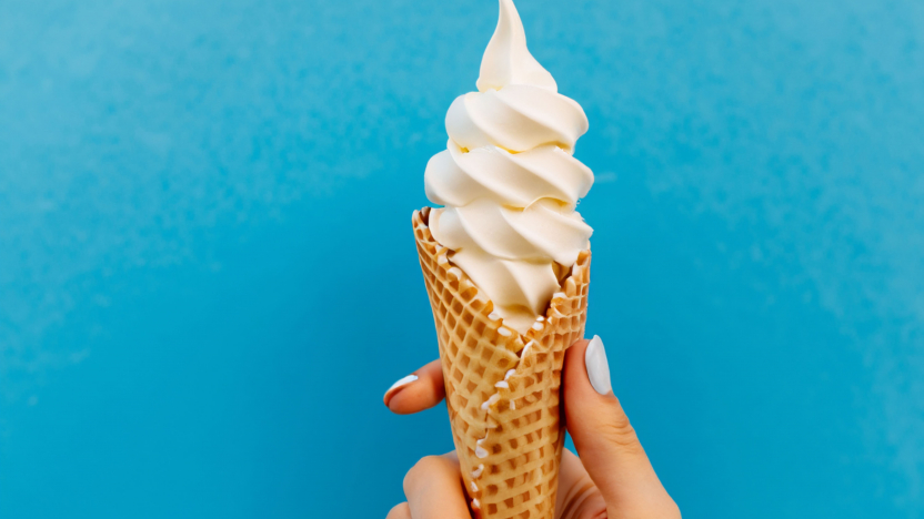 cône de crème glacée sur fond bleu. La femme tenant la glace à la main.